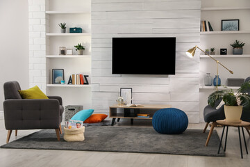 Cozy room interior with stylish furniture, decor and modern TV set