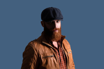 Fototapeta premium Brutal man in leather jacket. Man in retro peaky cap. Male formal fashion. Brutal bearded guy. Gangster with beard. Bearded man gangster. Stylish Englishman. Retro man isolated on grey