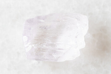 sample of rough kunzite mineral on white marble