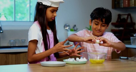 Indian Asian small sibling kids cooking with eggs and flour in modern kitchen, playful brother and sister mixing ingredients using spatula and utensils, learning baking, childhood fun - Powered by Adobe