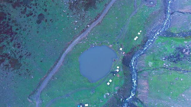 Aerial view of Chinar Lake nestled in Surgen Valley near Noori Top amid alpine terrain. Pakistan