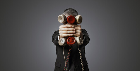 Office worker holding many telephone receivers