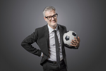 Corporate businessman holding a soccer ball