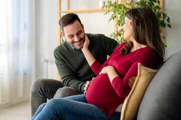 Obraz premium Man in love hugs his pregnant wife, they are waiting together for the baby's arrival. Love, family