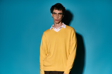 Stylish young man exudes confidence in vibrant yellow attire against a blue backdrop