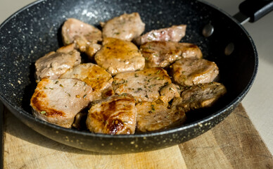 Close Up of Golden Brown Fried Pork Fillets Loins in a Pan with Herbs