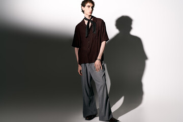 Stylish young man exudes confidence in fashionable attire under soft lighting