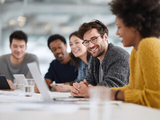 Diverse team collaborating, smiling around a table. Modern office vibe. Ideal for illustrating teamwork, meetings, and successful cooperation.