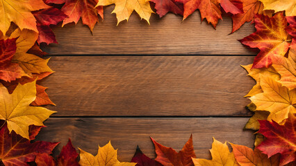 Obraz premium Colorful autumn leaves framing a wooden surface in a cozy setting