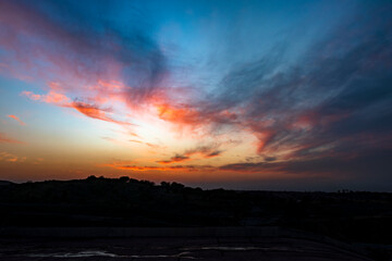 Colorful Sunset Sky with Vibrant Clouds over Silhouetted Landscape