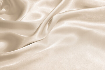 The texture of the satin fabric of beige color for the background