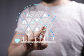 Futuristic healthcare technology concept.  Man interacts with a digital interface showing medical icons and data.
