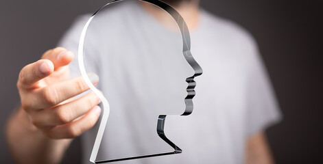Abstract image of a person holding a translucent head shape, symbolizing ideas, thoughts, or identity.