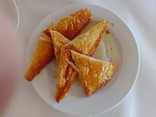 Cheese pie pieces served with honey as an appetizer