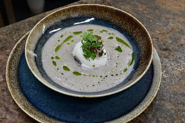 Traditional mushroom soup with egg, served as a warm autumn comfort food. Rustic homemade dish...