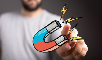 Stock photo of hand interacting with a magnet, symbolizing attraction, engagement, and powerful...