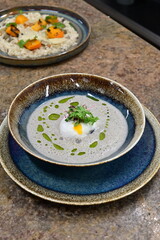 Traditional mushroom soup with egg, served as a warm autumn comfort food. Rustic homemade dish perfect for illustrating seasonal cuisine, hearty meals, and classic culinary traditions
