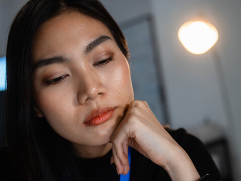 Late Night Office Tired Young Asian businessman working overtime, Fatigue, Sleepy and Burnout Boring while work at desk in office. Close-up Stressed woman office worker Feeling Tired while work.