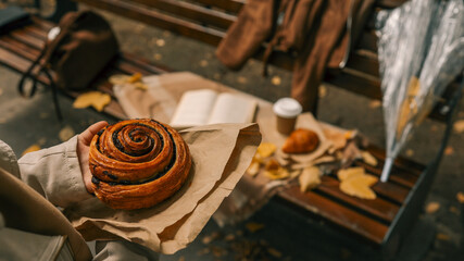 Autumnal scene with pastry and coffee on a park bench