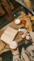 Autumn picnic scene with coffee, croissant, and a book.