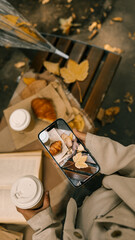 Autumn picnic scene with coffee, croissant, and fall leaves