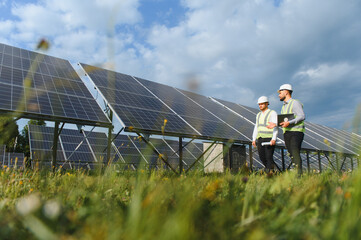 Engineers inspecting solar power plant for renewable energy efficiency