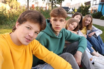 Group of teenagers taking selfie in park