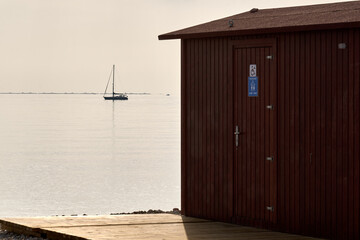 Public restroom by peaceful water, Altea, Spain, daylight, dual cabins, minimal, horizontal, functional, accessibility, travel, informational use