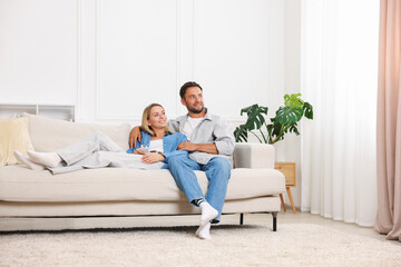 Happy couple spending time together on sofa at home