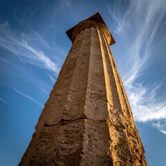 Ancient stone column against a vibrant sky