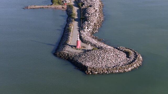 Approaching drone fly to the Farol da Barra breakwater and visitor's viewpoint with lighthouse, Itajaí, Santa Catarina, Brazil.