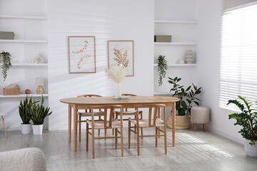 Stylish wooden table with chairs and decor indoors. Interior design