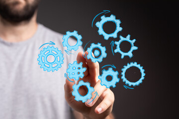 Abstract image of a man interacting with digital gears, representing teamwork, process, innovation, and technology.