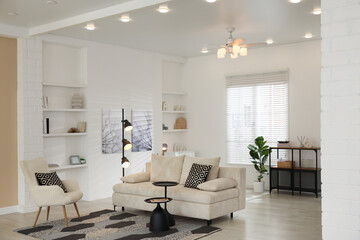 Stylish living room with lamp, houseplant and sofa. Interior design