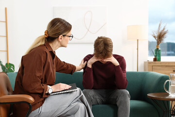 Professional psychologist working with teenage boy in office