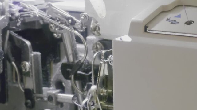 Sewing machine close-up reveals complex mechanisms at work in a bright workshop
