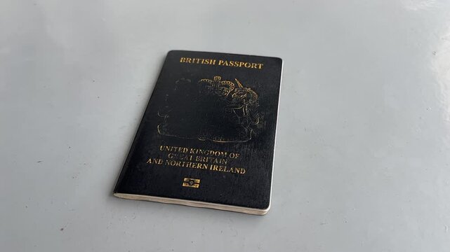 POV close up of a man holding a British passport travel identification document UK damaged bad condition