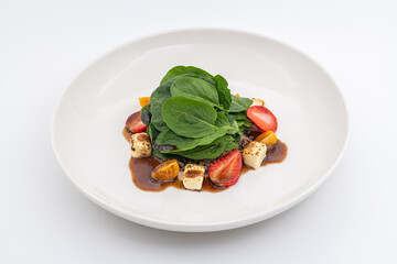 Fresh green salad with lime, strawberries, and nuts served