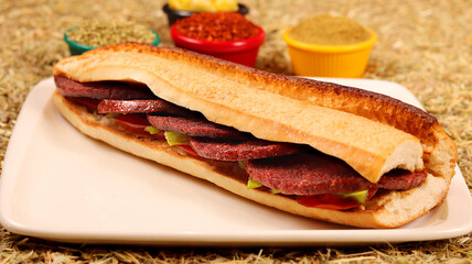 a sandwich with sausage, vegetables,bread, peppers and spices,big close up view
