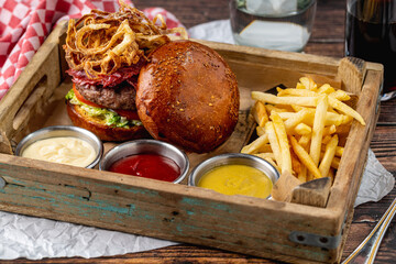 Gourmet beef burger with pastrami, cheddar, caramelized onions, and fries