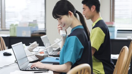 電話対応をするアジア人介護士