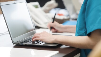 事務仕事をするアジア人介護士の手元