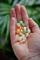 Skin care products. Multicolored Korean capsules with facial serum in hand.