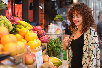Smiling woman shopping for fresh fruit at outdoor market