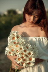 a bouquet of white daisies in close-up in the hands of a girl. film and grain effect