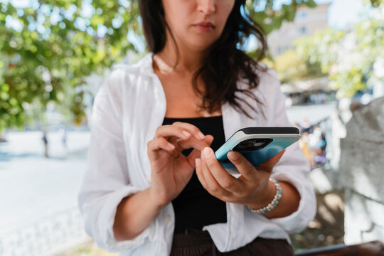 Person using smartphone outdoors in urban setting
