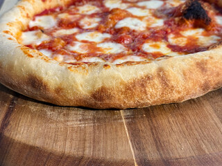 Tasty vegetarian pizza with cherry tomatoes, mozzarella cheese and fresh oregano. Close up. traditional wood-fired Neapolitan Margherita pizza with a golden, crispy crust and melted mozzarella 