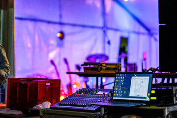 An audio engineer or sound technician operates a mixing board and laptop, managing the sound for a...