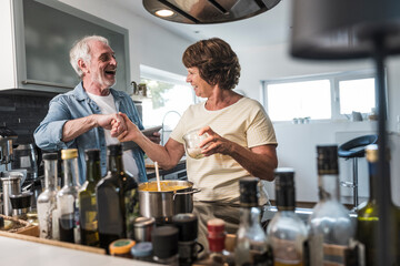 Senior couple doing handshake in kitchen at home