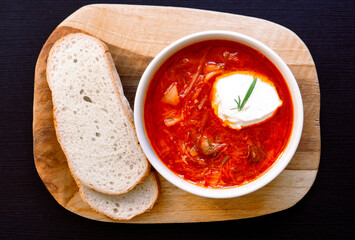 ukrainian borsch with red cream, on a wooden board. top view, free space for your text